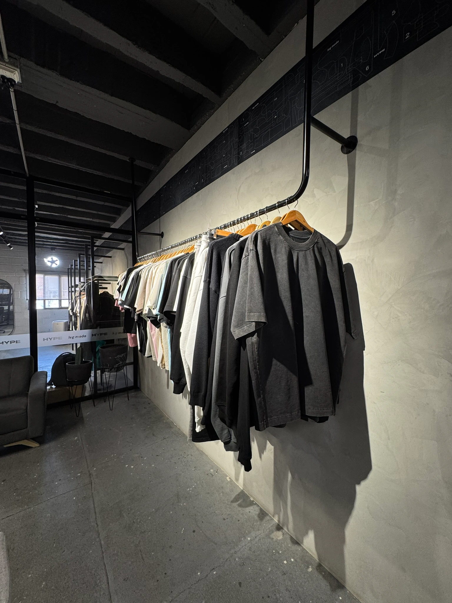 Percha de camisetas Classior colgadas en la pared de la tienda